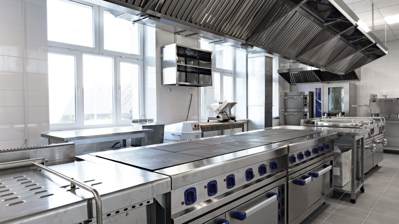 This spacious kitchen features stainless steel counters and equipment, providing a professional environment for chefs to prepare meals efficiently and effectively.