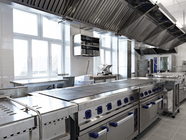 This spacious kitchen features stainless steel counters and equipment, providing a professional environment for chefs to prepare meals efficiently and effectively.