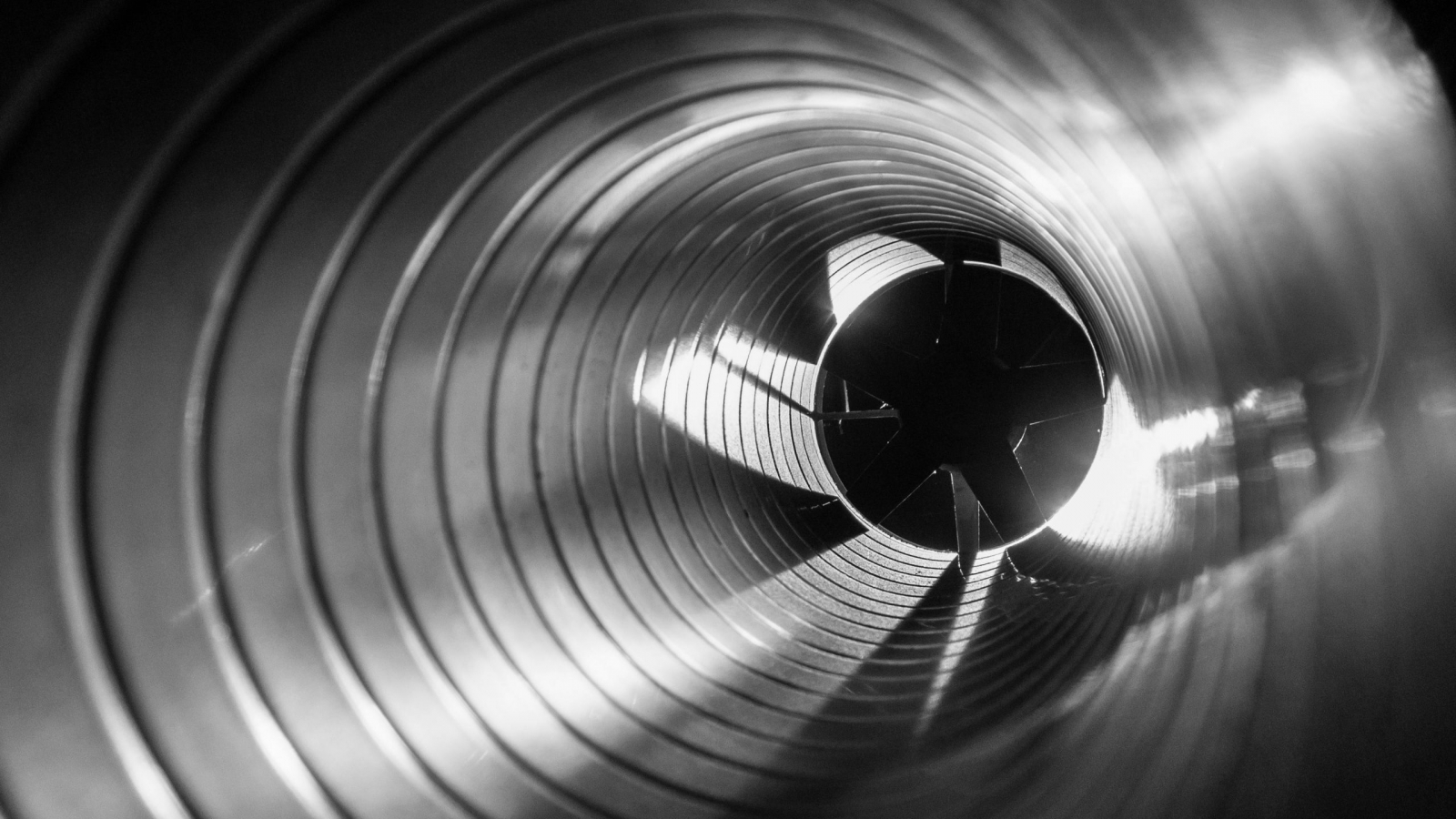 closeup view from inside the galvanized steel air duct on the exhaust fan in the background light, the front and back background is blurred with a bokeh effect